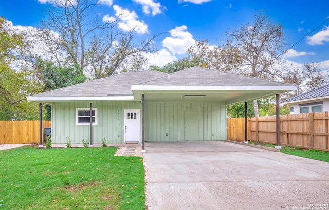 view of front facade with a front lawn and a carport