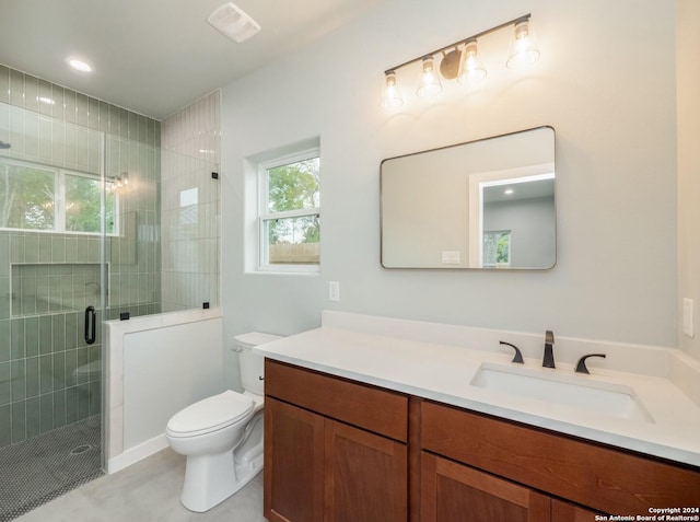 bathroom with vanity, toilet, and a shower with door