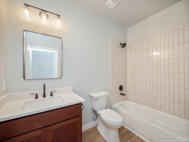 full bathroom featuring hardwood / wood-style floors, vanity, toilet, and tiled shower / bath