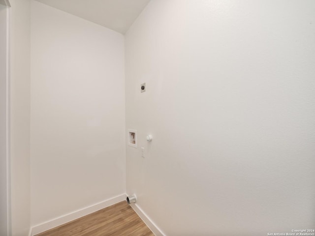 clothes washing area with hookup for an electric dryer, wood-type flooring, and washer hookup