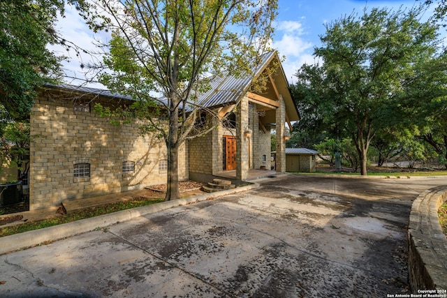 694 Scenic Cir, Pipe Creek, TX 78063 - view of front of property featuring driveway and a metal roof