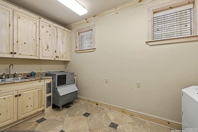 694 Scenic Cir, Pipe Creek, TX 78063 - laundry room featuring cabinet space, light stone finish floors, and crown molding