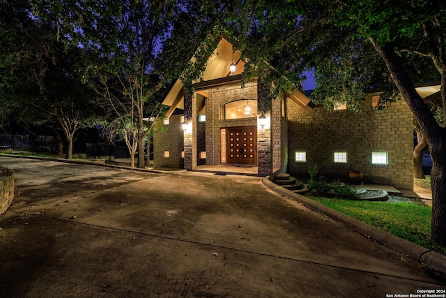 694 Scenic Cir, Pipe Creek, TX 78063 - view of front of home featuring stone siding, concrete driveway, and french doors