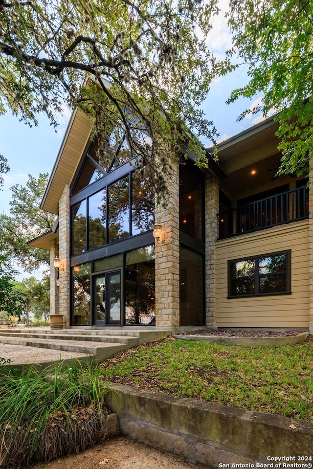 694 Scenic Cir, Pipe Creek, TX 78063 - back of property with a balcony and stone siding