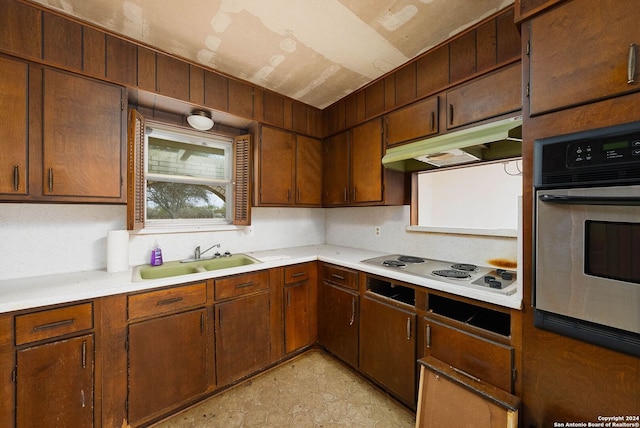 kitchen featuring stainless steel oven, white cooktop, and sink