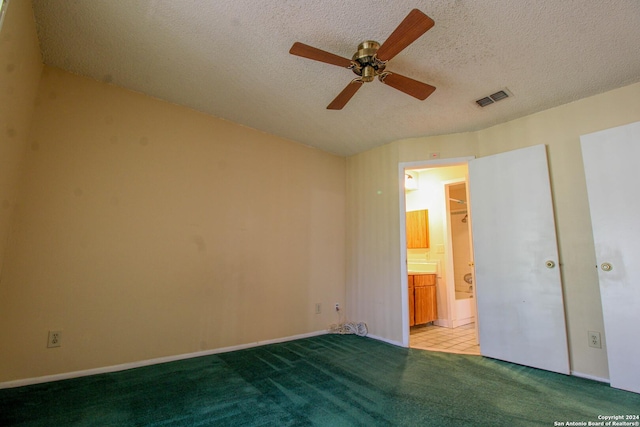 unfurnished bedroom featuring ensuite bathroom, ceiling fan, light carpet, and a textured ceiling