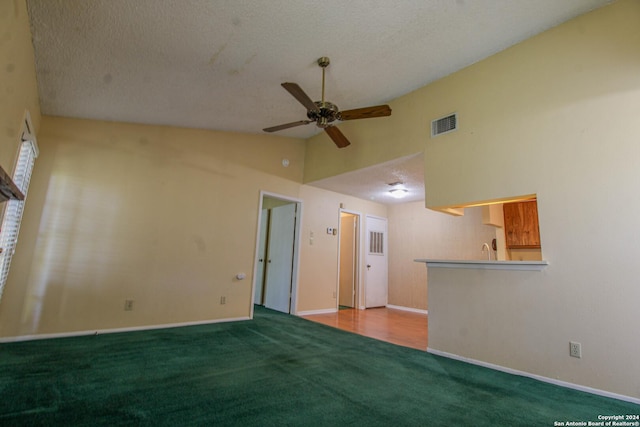 spare room featuring carpet flooring, ceiling fan, and a textured ceiling