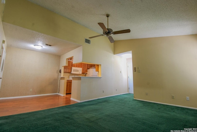 unfurnished living room featuring a textured ceiling, ceiling fan, carpet, and lofted ceiling