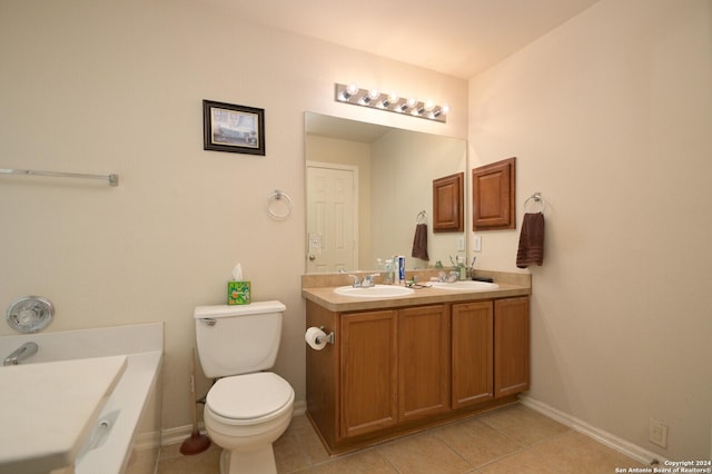 bathroom with tile patterned floors, a tub to relax in, vanity, and toilet