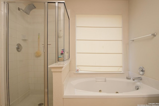 bathroom featuring shower with separate bathtub