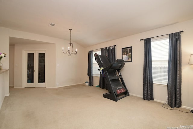 exercise area with a notable chandelier, light colored carpet, and lofted ceiling