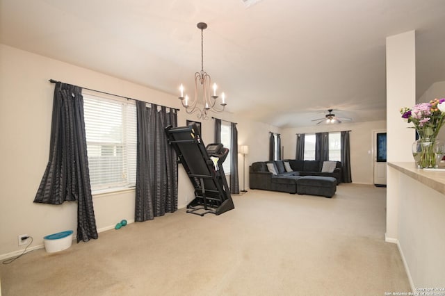 workout area featuring a wealth of natural light, light carpet, and ceiling fan with notable chandelier