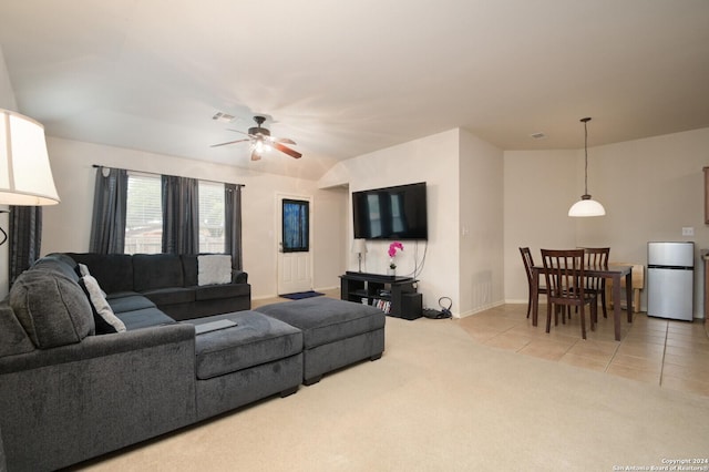 tiled living room featuring ceiling fan and vaulted ceiling