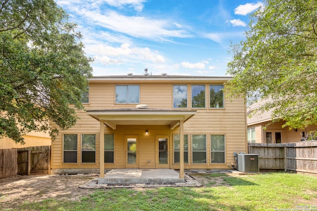 rear view of house featuring a patio, central AC, and a lawn