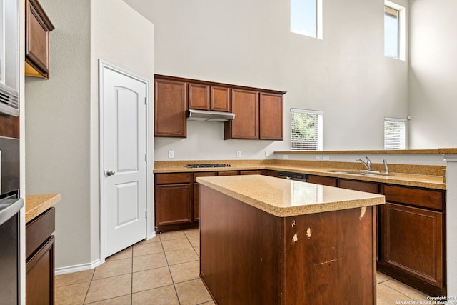 kitchen featuring sink, light tile patterned floors, a kitchen island, kitchen peninsula, and stainless steel gas cooktop