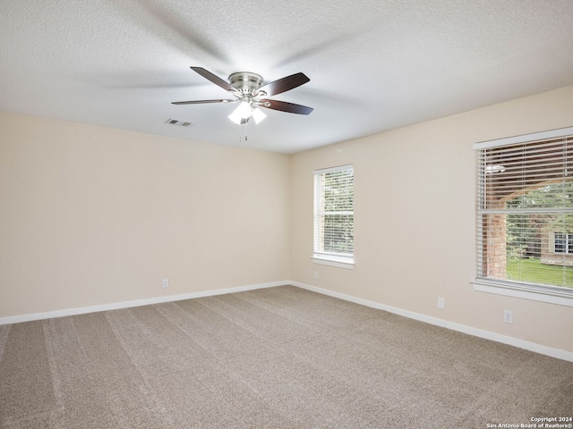 carpeted empty room with a textured ceiling and ceiling fan