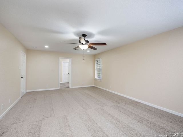 spare room featuring light carpet and ceiling fan