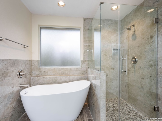 bathroom featuring tile walls and shower with separate bathtub