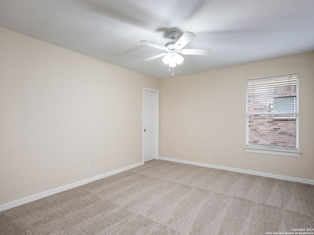 empty room featuring carpet flooring, ceiling fan, and a textured ceiling