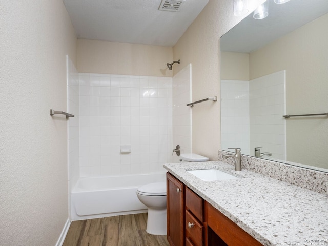 full bathroom with hardwood / wood-style floors, a textured ceiling, toilet, shower / tub combination, and vanity