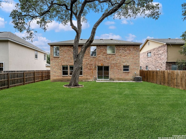 rear view of house featuring a yard and central AC unit