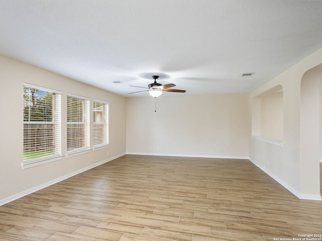 empty room featuring ceiling fan, a textured ceiling, and light hardwood / wood-style flooring