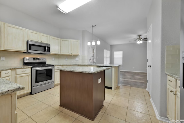 kitchen with decorative backsplash, appliances with stainless steel finishes, ceiling fan, sink, and hanging light fixtures