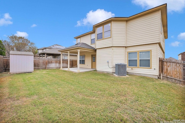 rear view of property featuring a yard, a shed, central AC unit, and a patio area