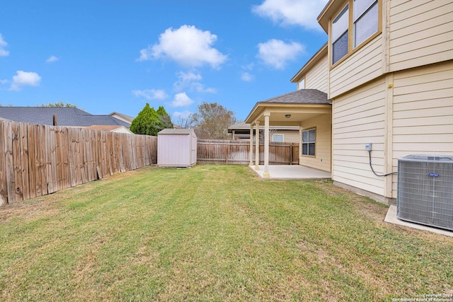 view of yard featuring central AC, a patio, and a storage unit