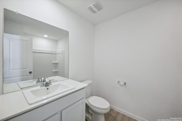 bathroom featuring vanity, wood-type flooring, and toilet