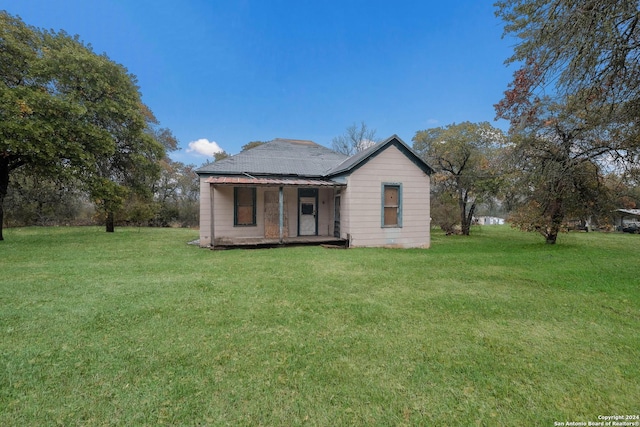 back of property featuring a lawn