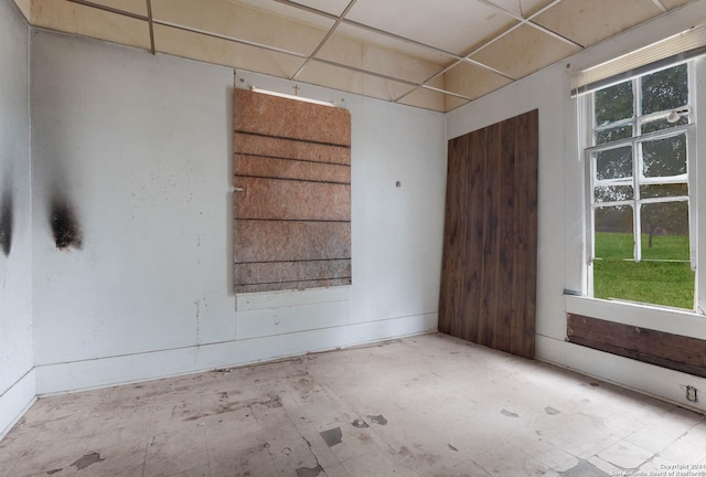 unfurnished room with a paneled ceiling and a wealth of natural light