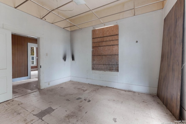 unfurnished room featuring wood walls