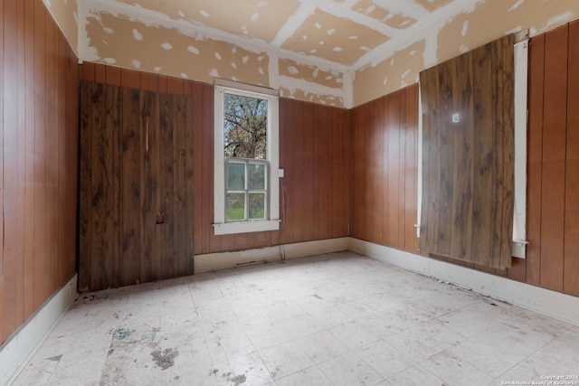 unfurnished room with wooden walls