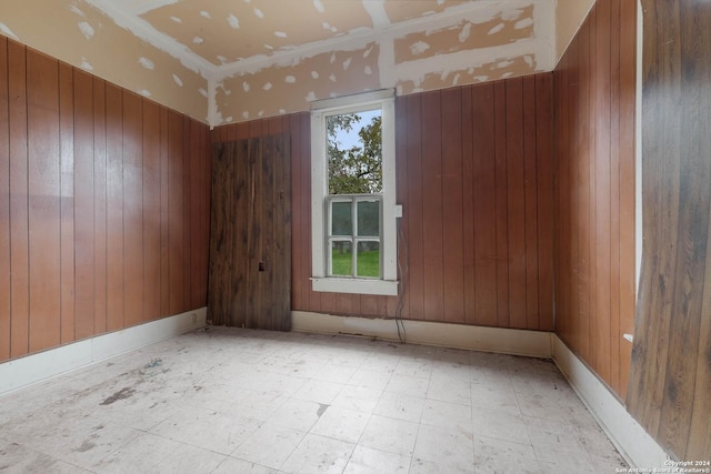 spare room featuring wood walls