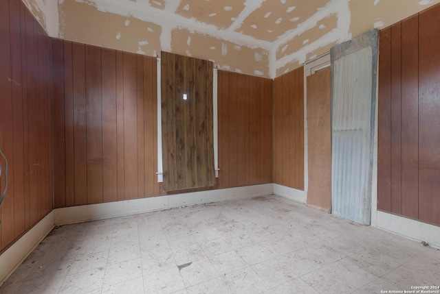 spare room with wood walls