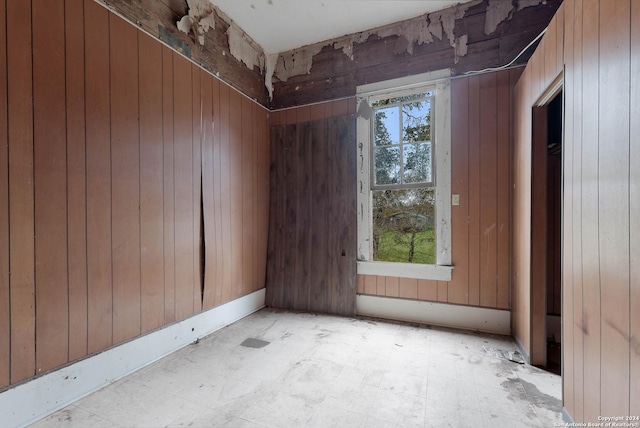 empty room with plenty of natural light and wooden walls