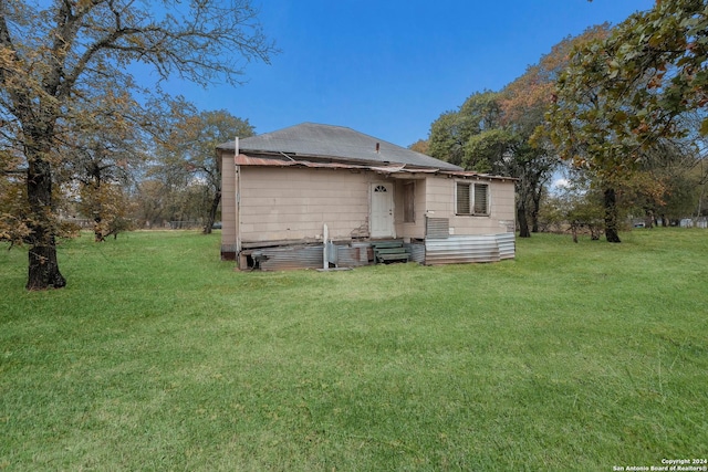 rear view of house featuring a yard