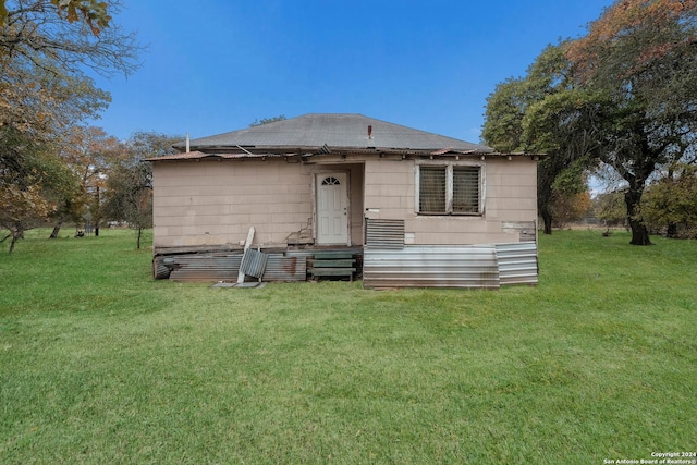 rear view of property with a lawn