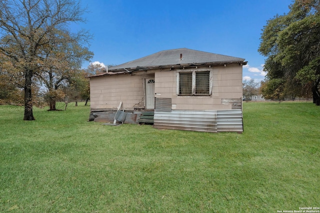 rear view of property with a yard