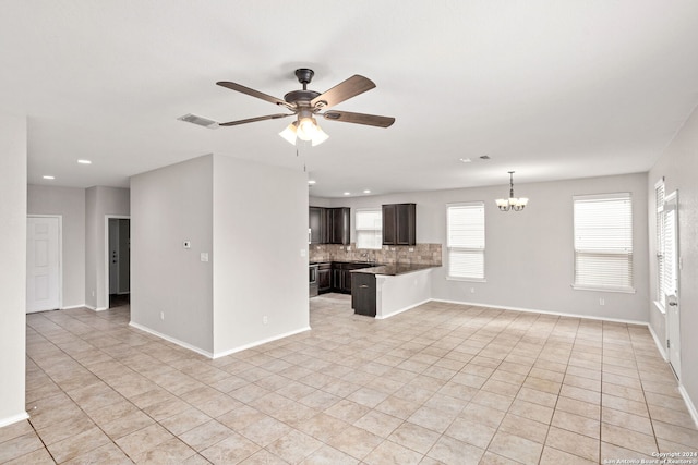 unfurnished living room with ceiling fan with notable chandelier and light tile patterned flooring