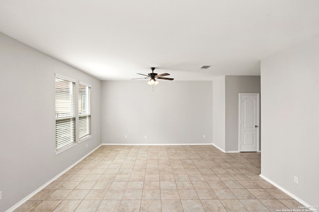 spare room with ceiling fan and light tile patterned flooring