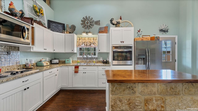 kitchen featuring appliances with stainless steel finishes, white cabinetry, and sink