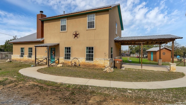 back of property featuring a storage shed