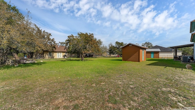 view of yard with central AC unit and a storage shed