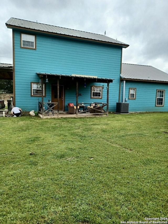 back of property featuring a lawn, a patio area, and central AC