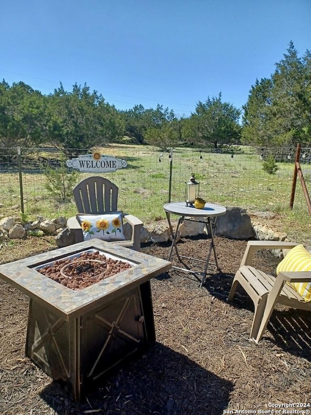 view of yard featuring a rural view and an outdoor fire pit