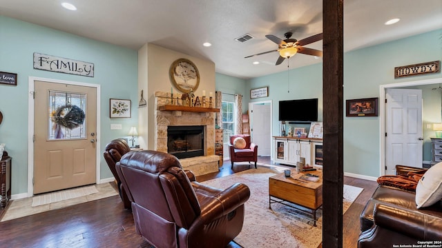 living room featuring ceiling fan, dark hardwood / wood-style flooring, and a fireplace