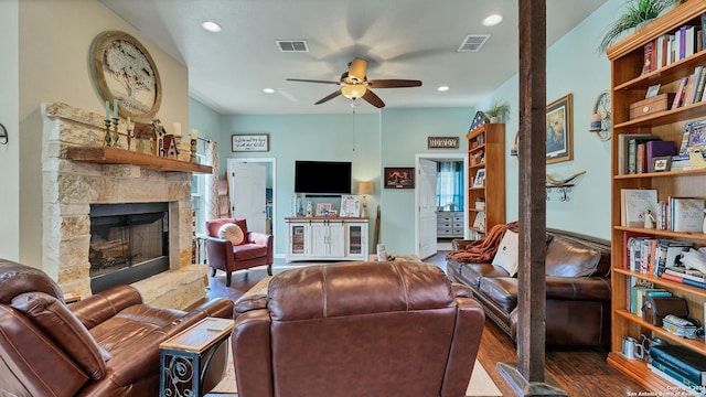 living room featuring dark hardwood / wood-style floors, ceiling fan, and a fireplace