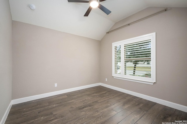 spare room featuring dark hardwood / wood-style floors, vaulted ceiling, and ceiling fan